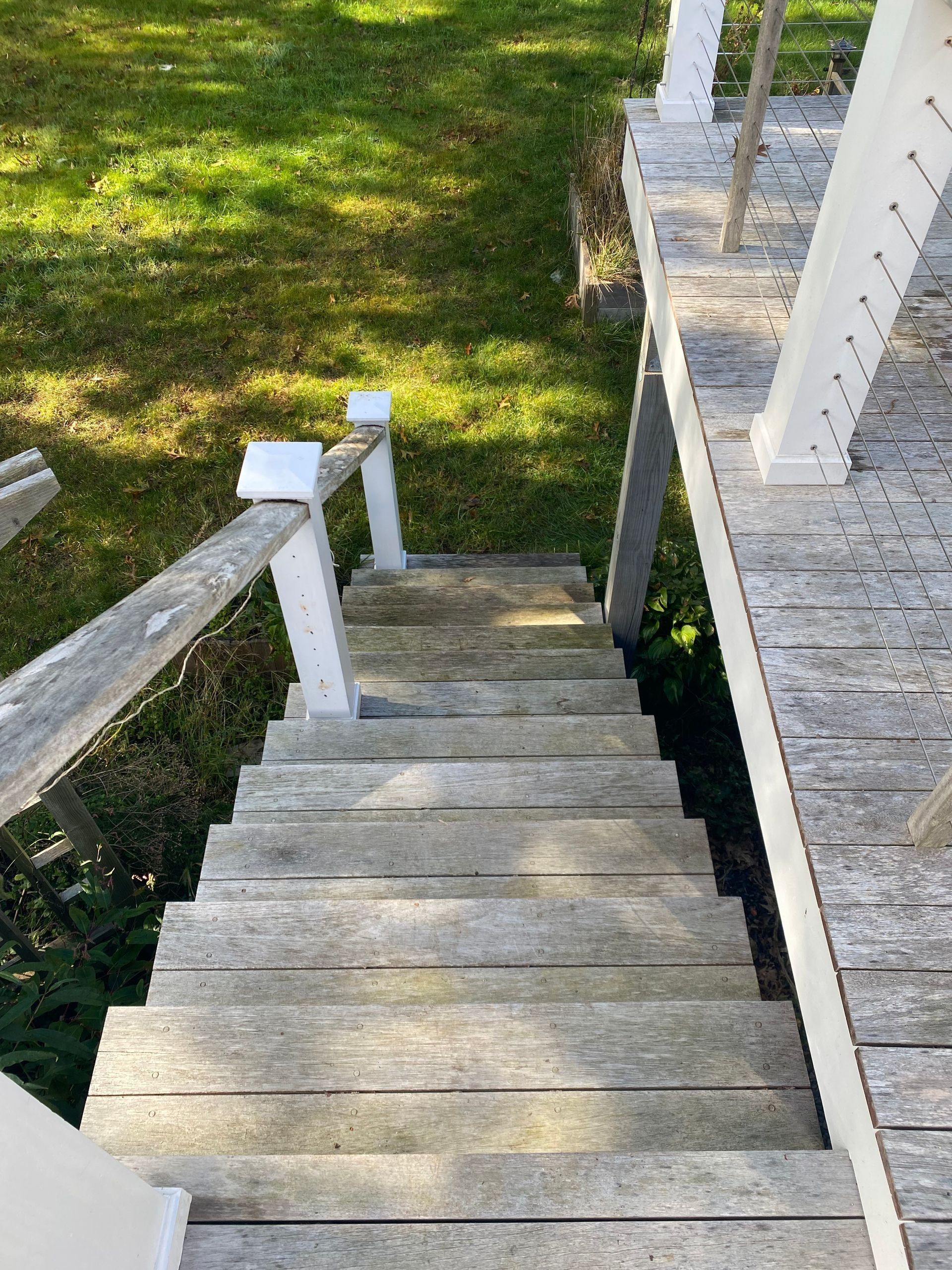 Wooden outdoor stairs leading down to grass.