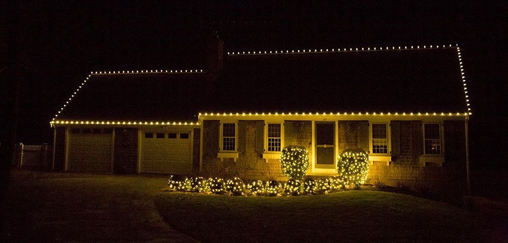 House decorated with Christmas lights at night.