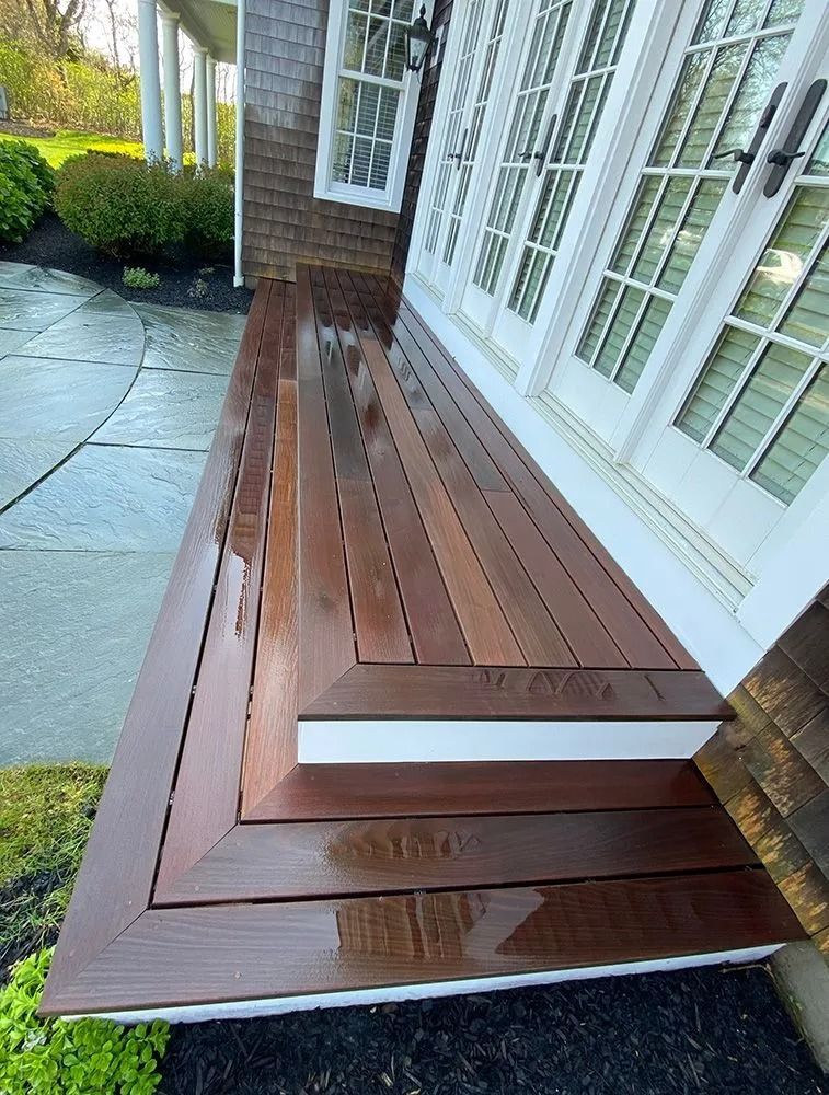 Wooden deck with steps, next to white French doors.