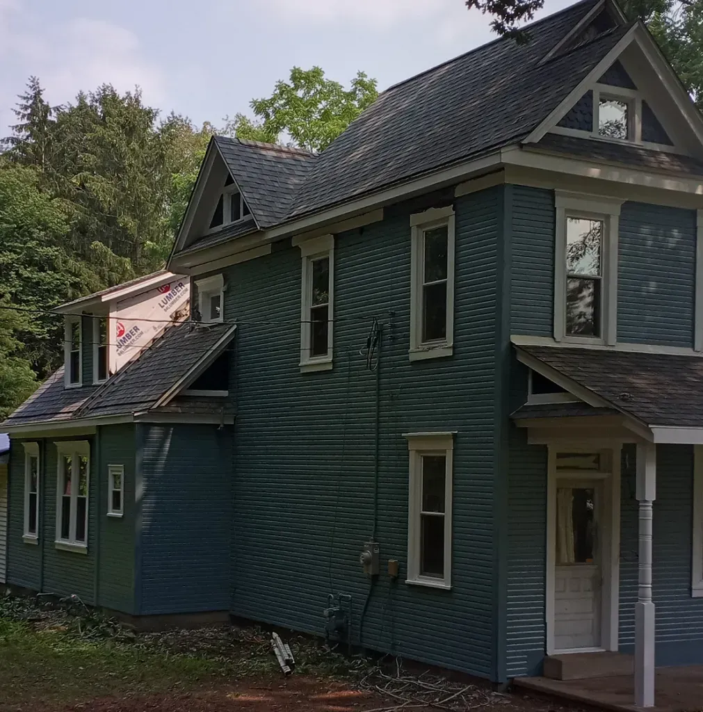 A blue house with a gray roof and white trim.