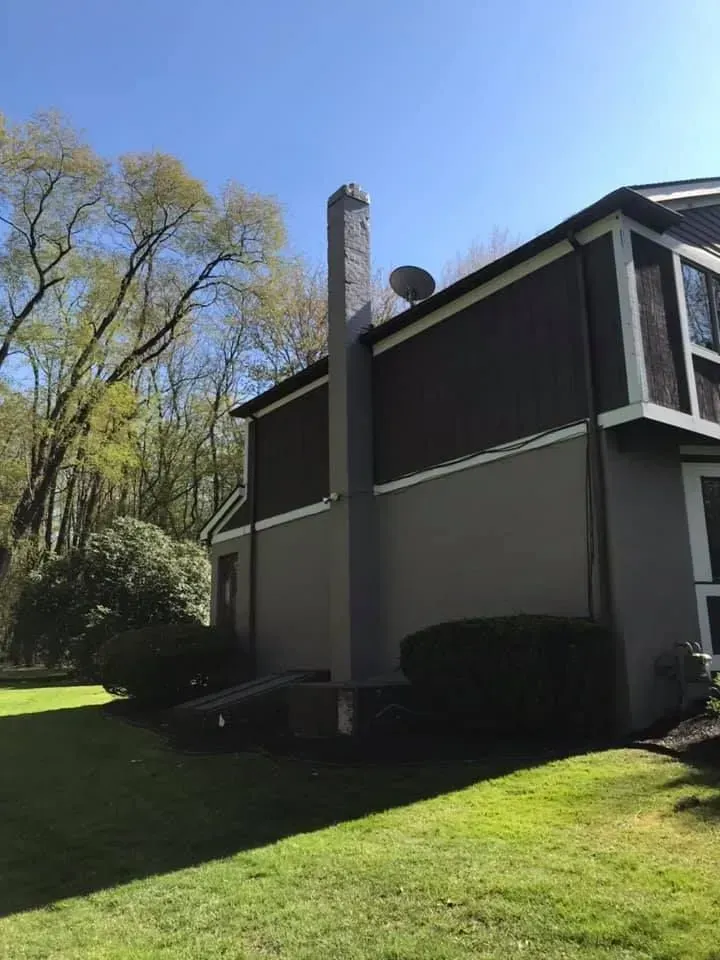 A blue house with a gray roof and white trim.