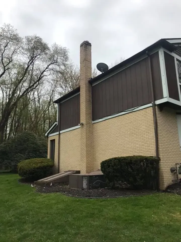 A house with a roof that has a chimney on it.