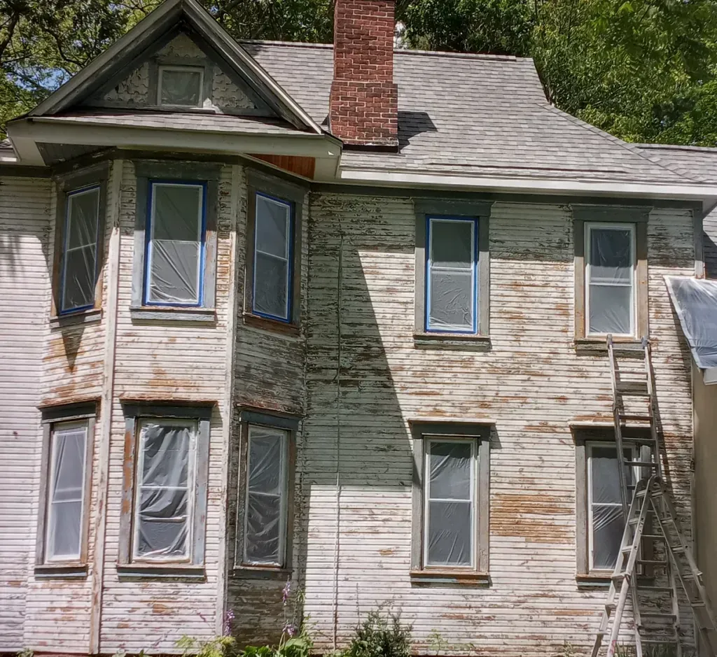 Before photo of an old white house.