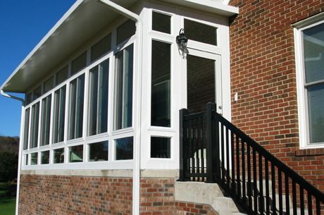 A brick house with a white porch and stairs