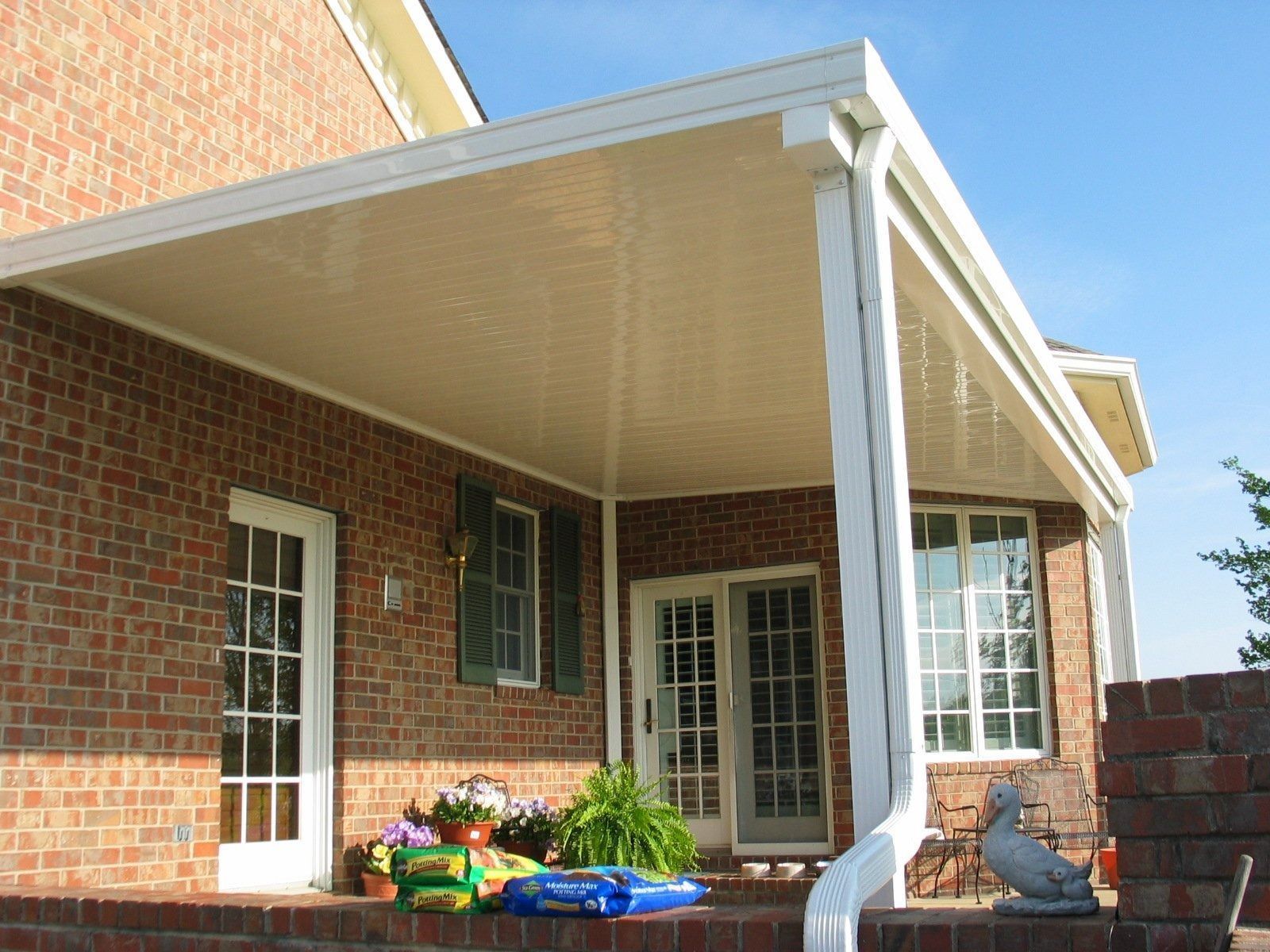 A brick house with a white porch and a statue of a bird