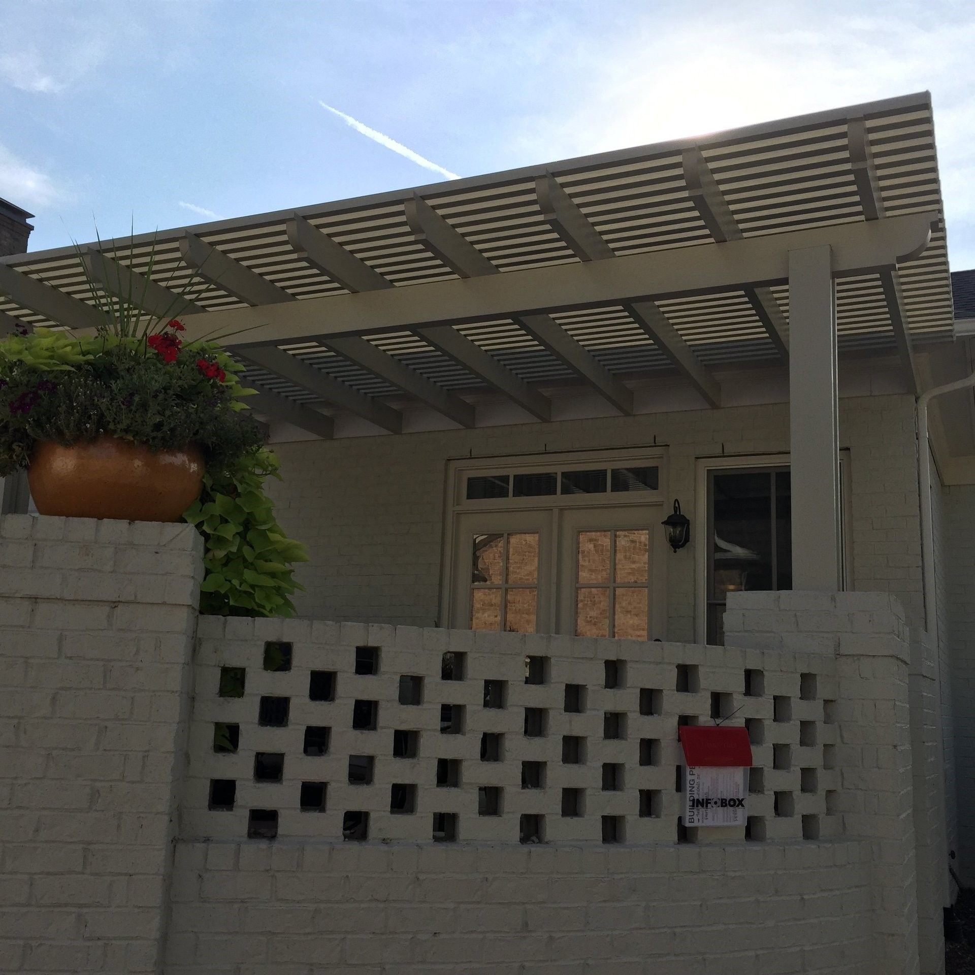 A white house with a pergola on top of it