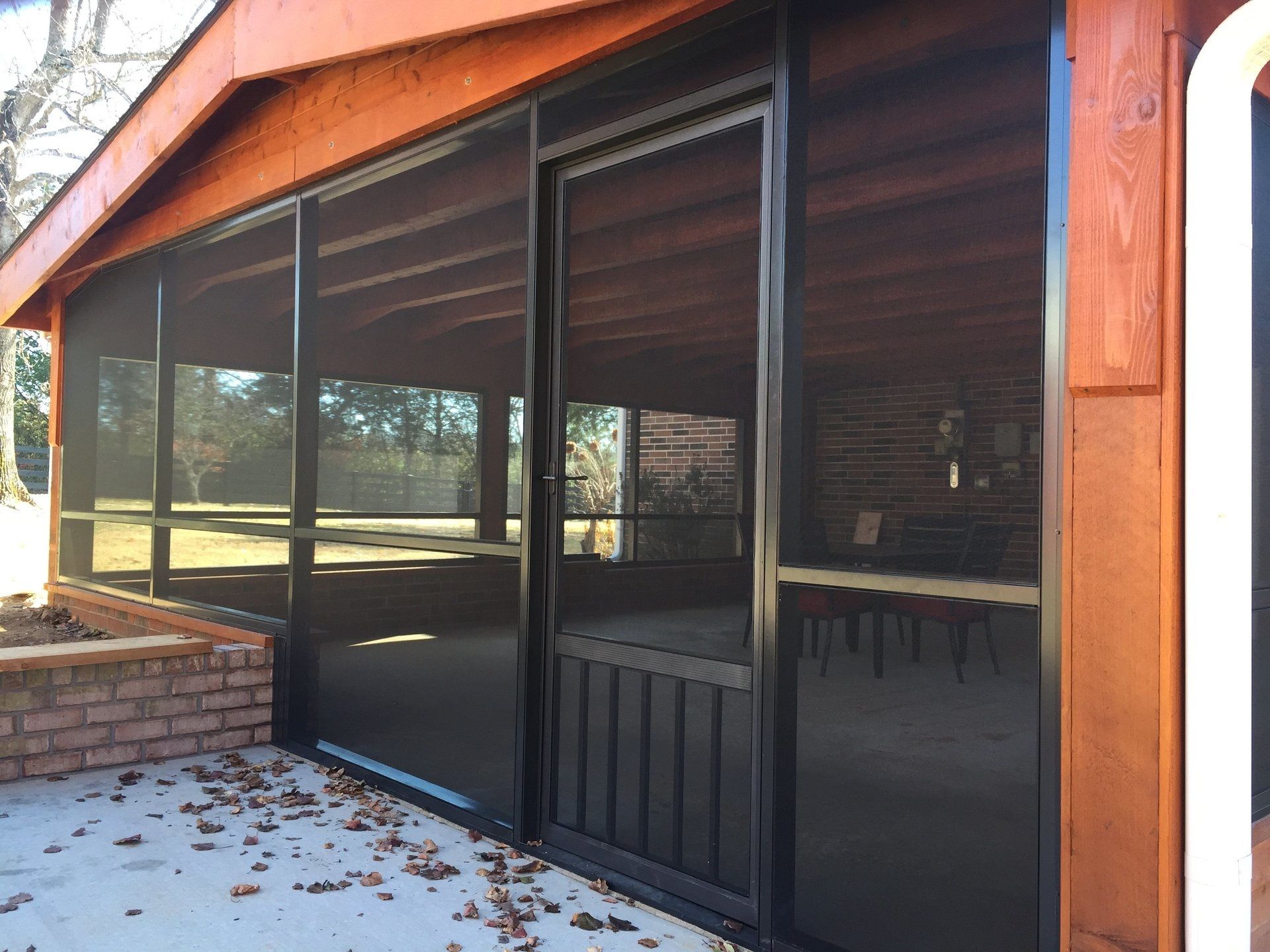 A screened in porch with a wooden roof