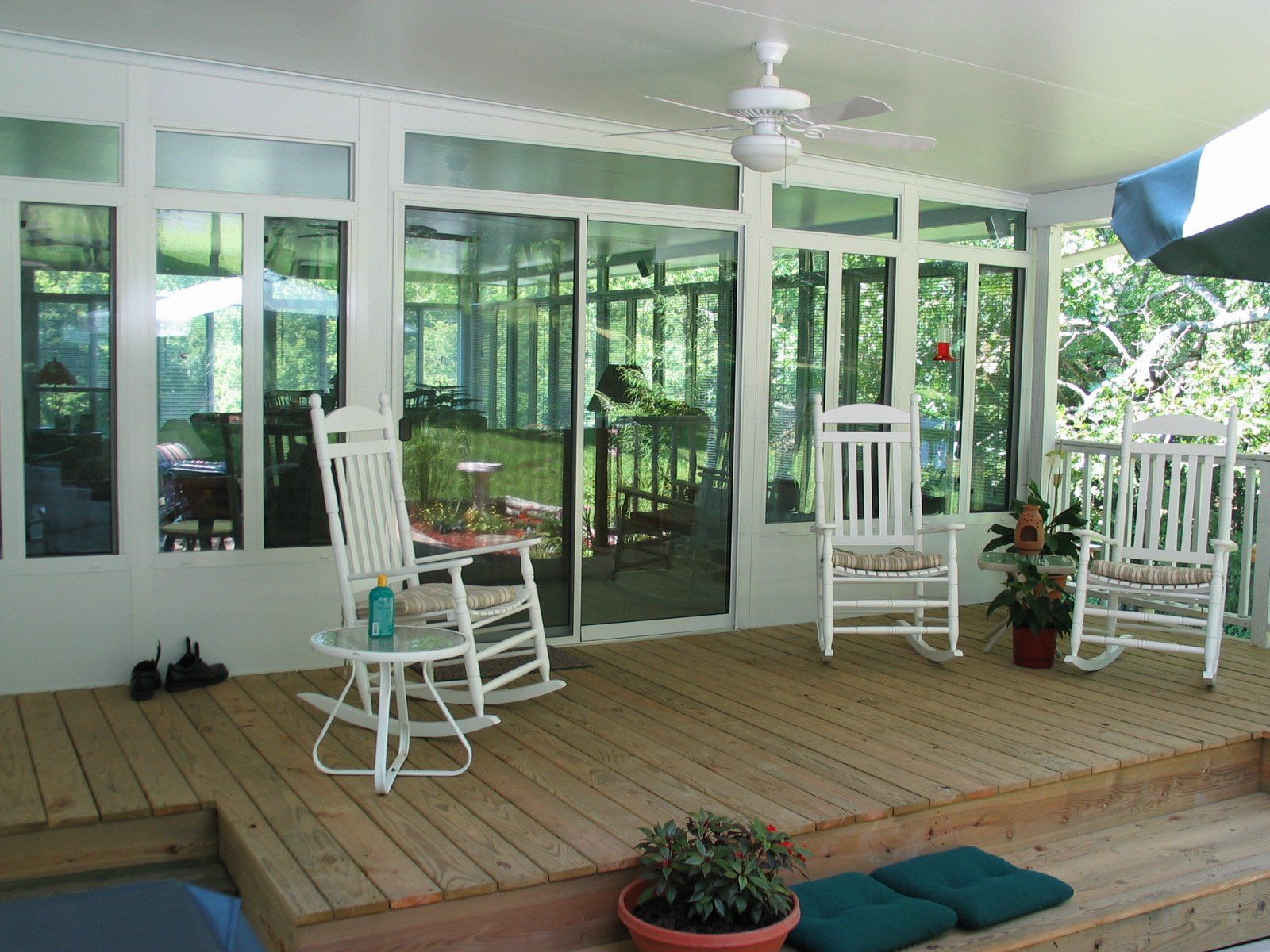 A porch with rocking chairs and a ceiling fan