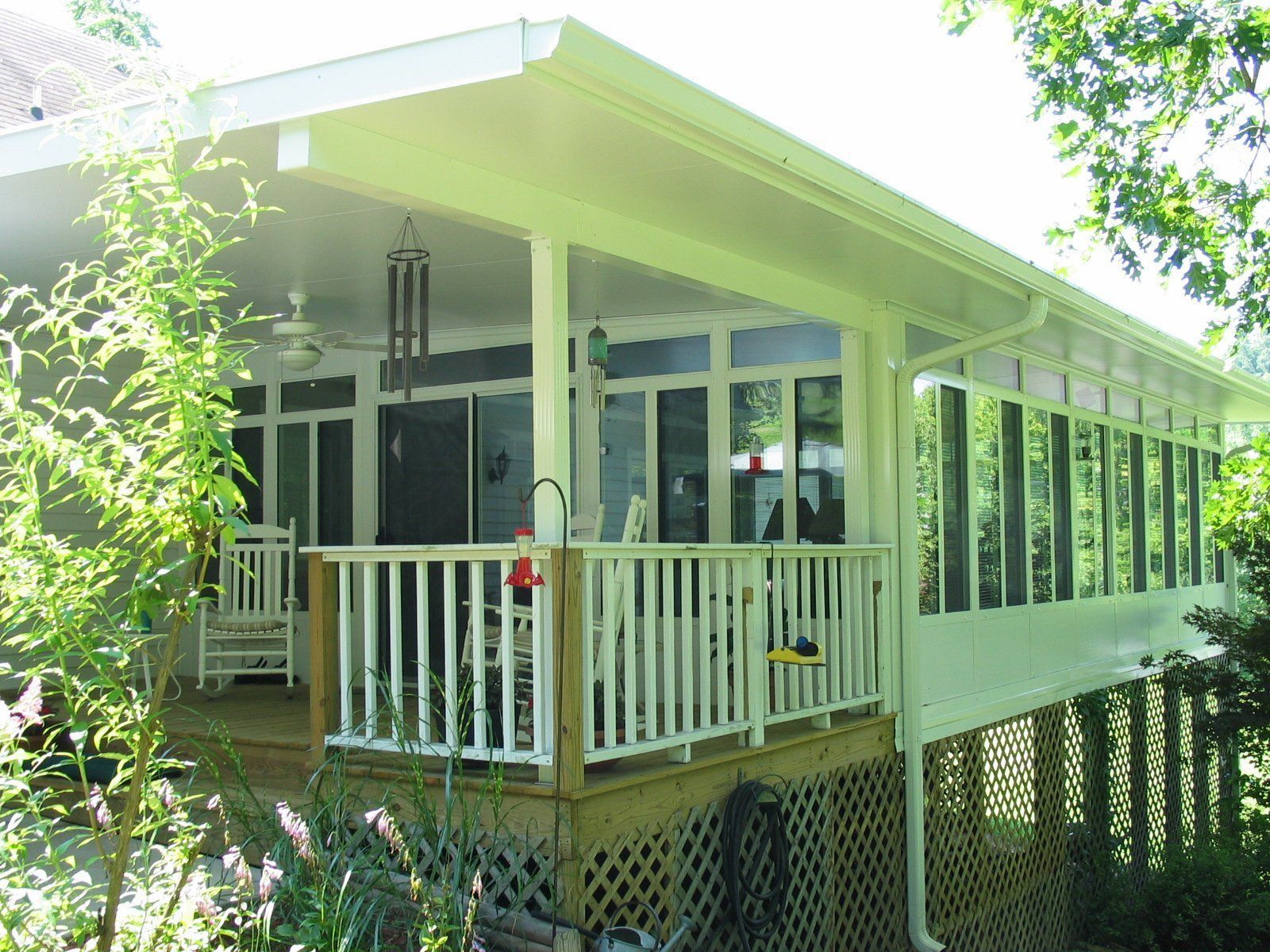 A house with a screened in porch and a white railing