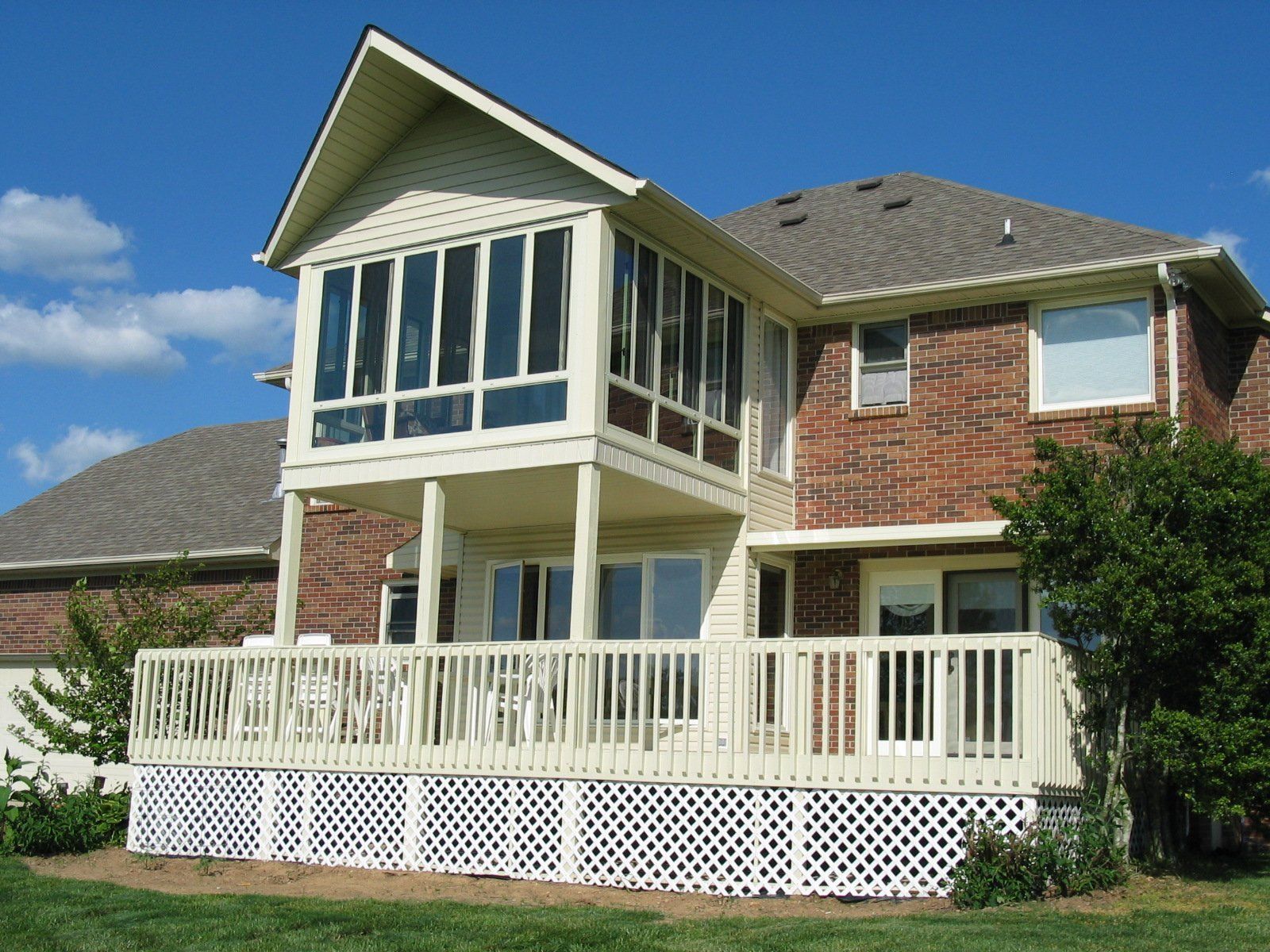 A large brick house with a large white deck