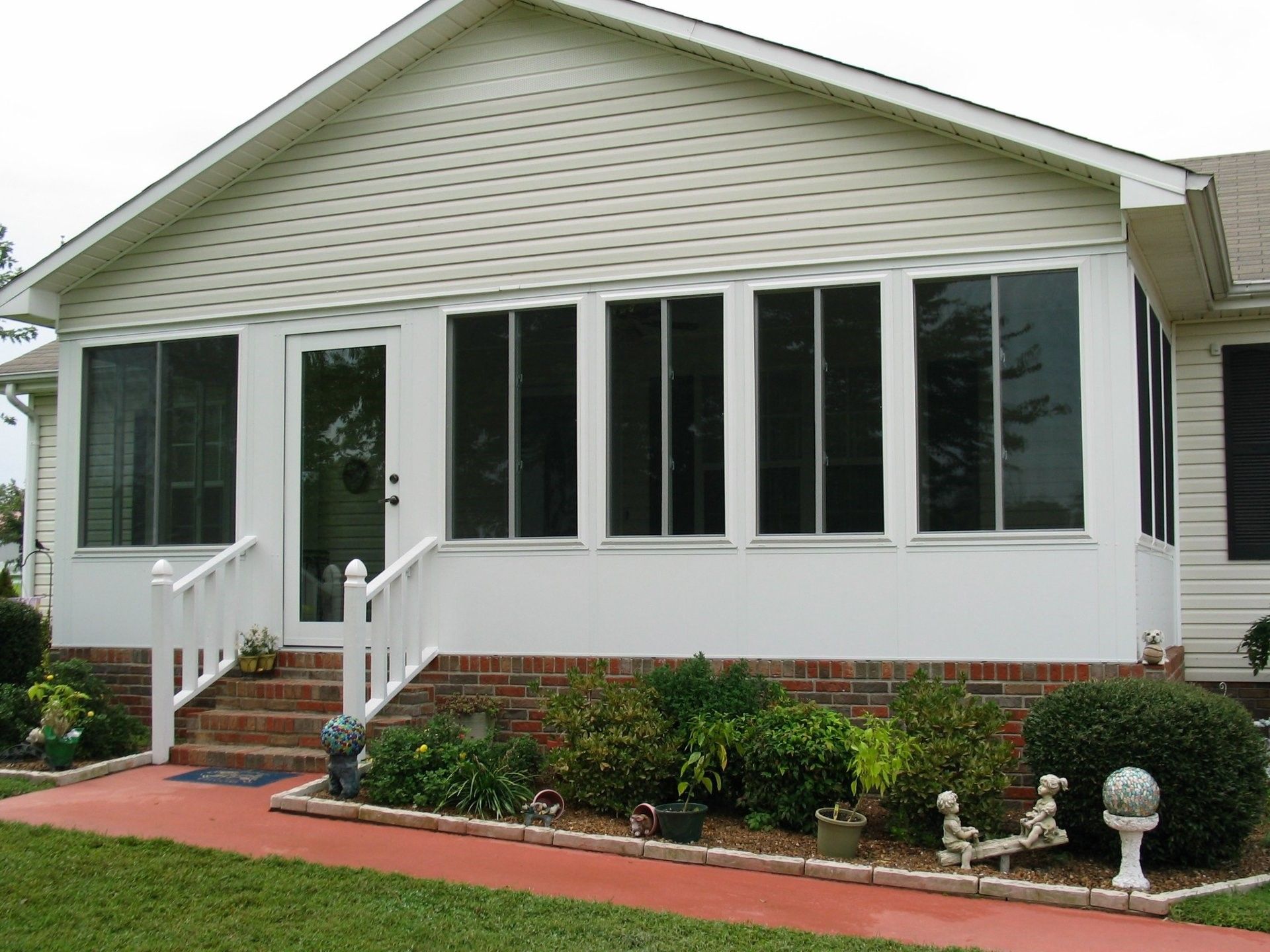A white house with a screened in porch and stairs