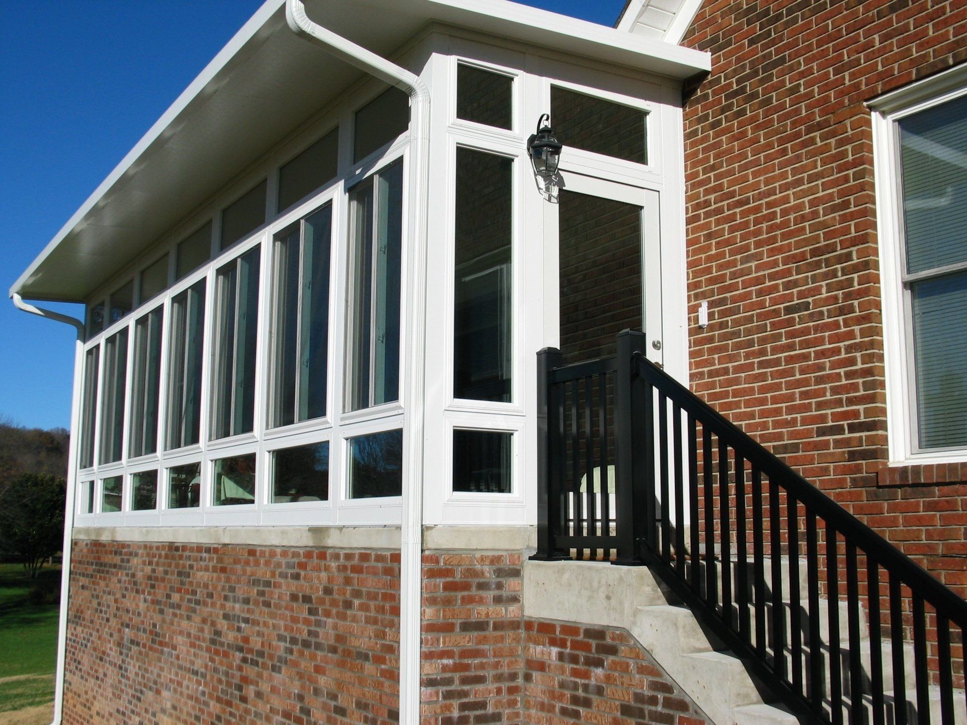 A brick house with a white porch and stairs