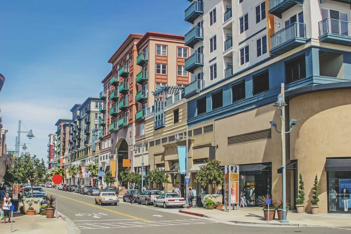 A city street with a lot of buildings and cars parked on the side of the road.