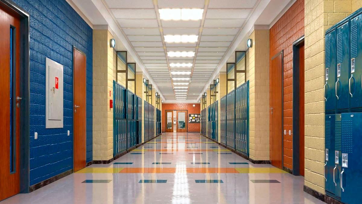 A long hallway in a school with lockers and doors.