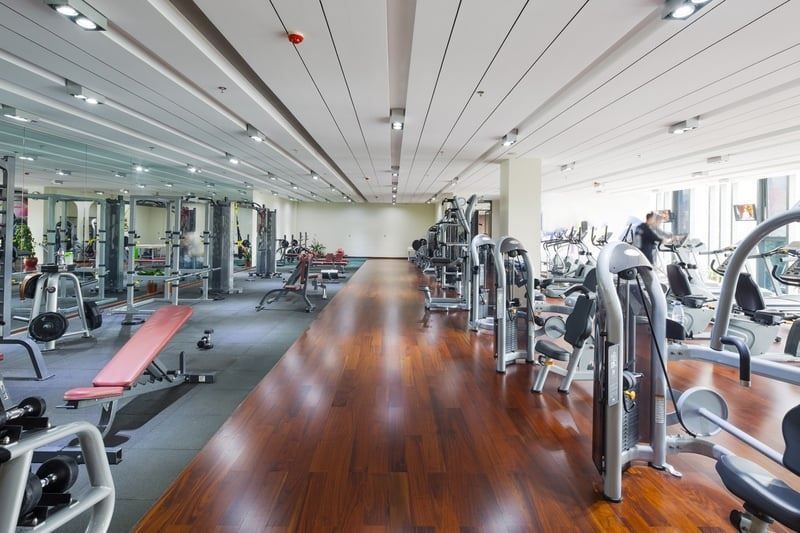 A large gym filled with lots of exercise equipment.