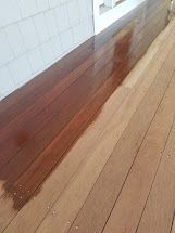 A wooden floor is being painted in a room.