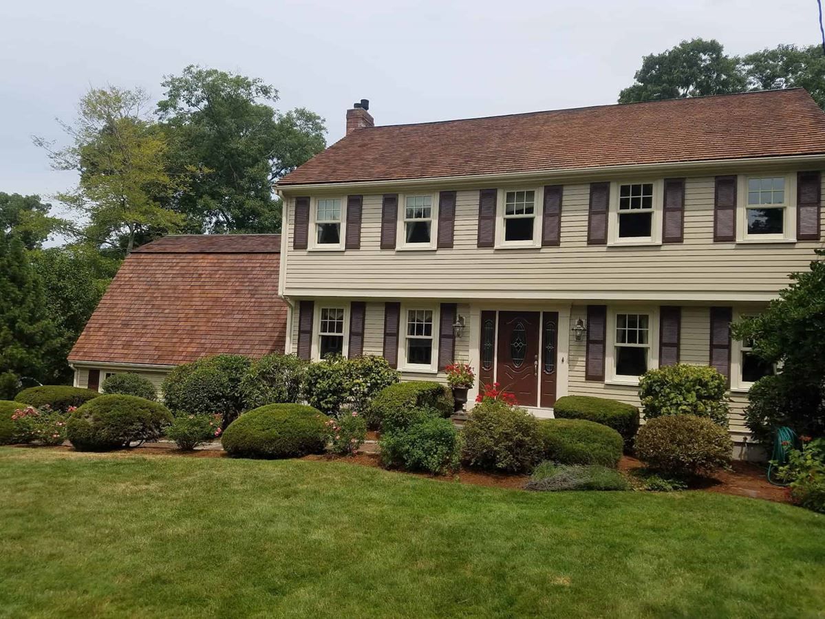 A large house with a brown roof and white shutters