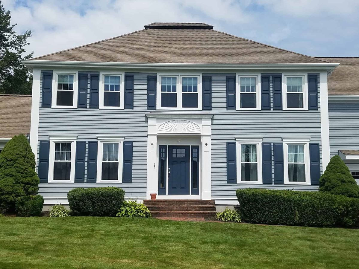 A blue house with white trim and blue shutters