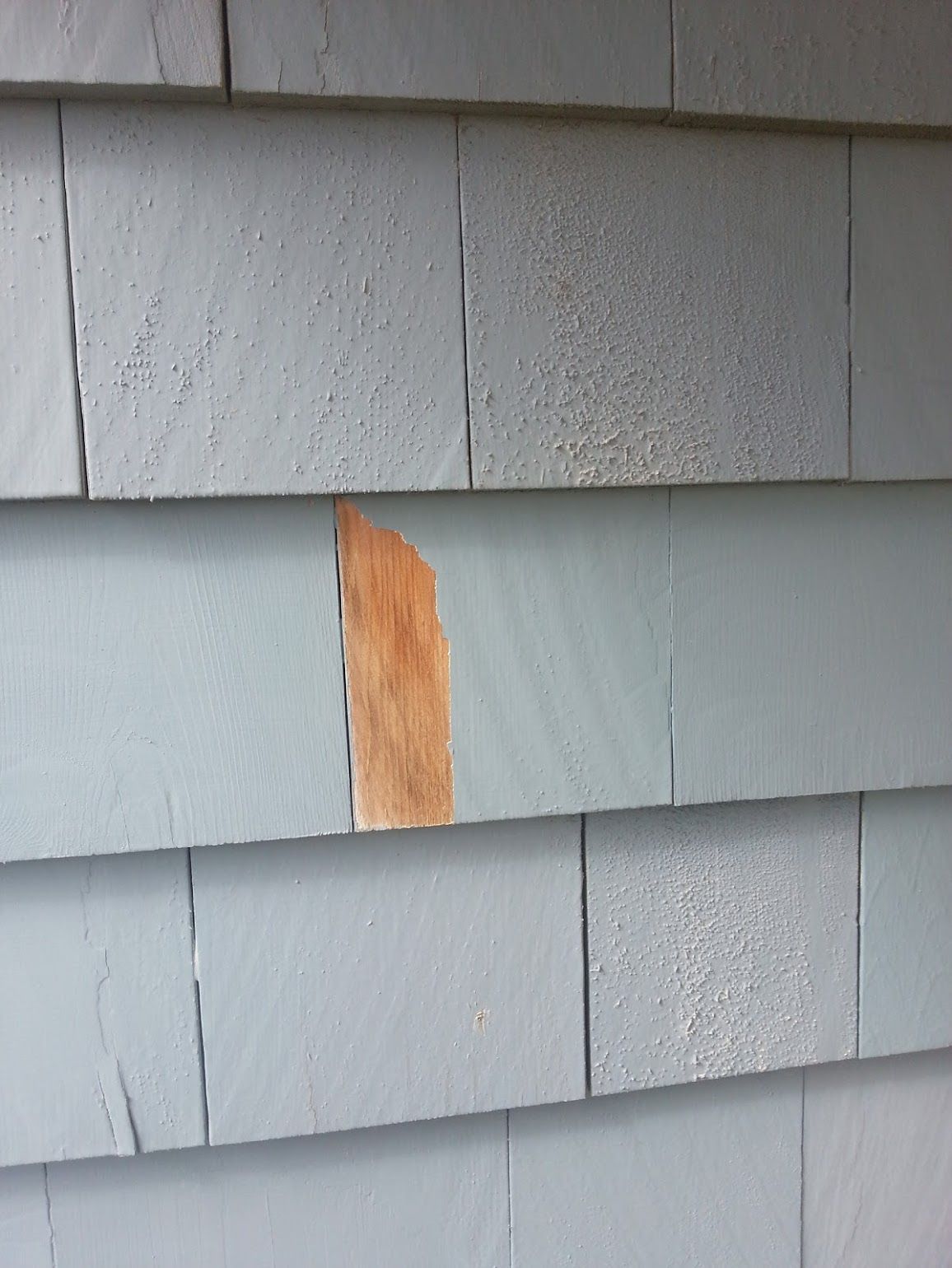 A close up of a siding with a piece of wood missing