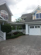 A large house with a white garage door and a white porch.