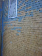 A brick wall with blue paint on it and a picture on it.