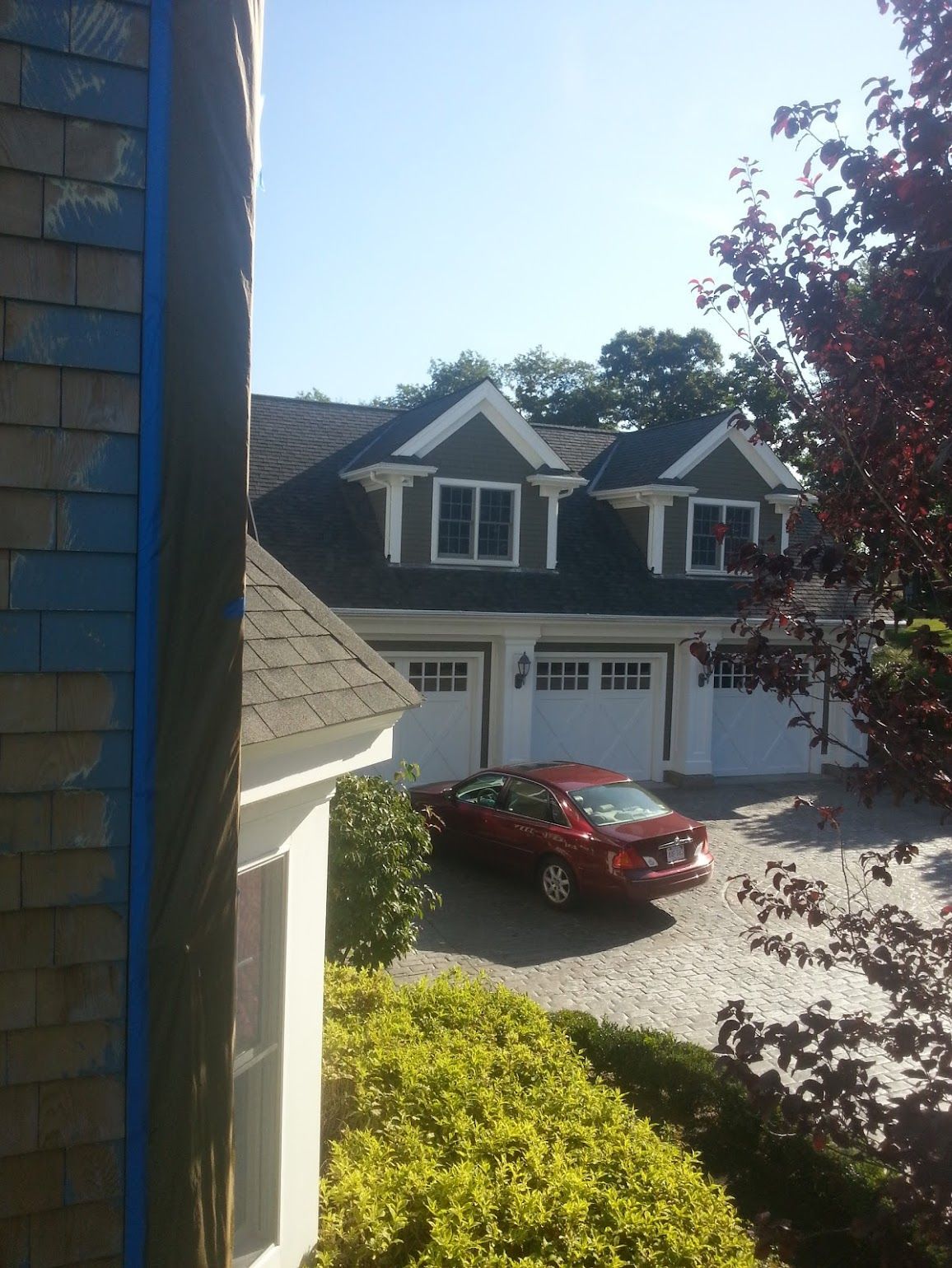 A red car is parked in front of a house