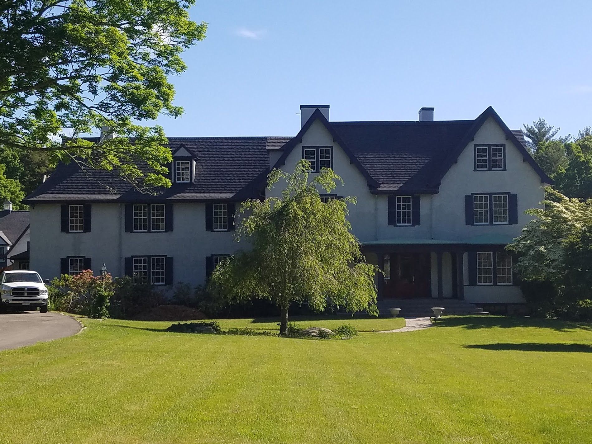 A large white house with a black roof and black shutters