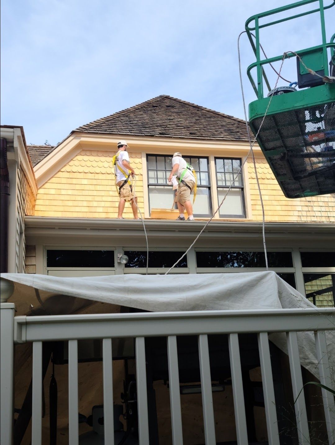 Two men are working on the roof of a house