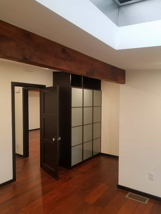 An empty room with hardwood floors and a closet
