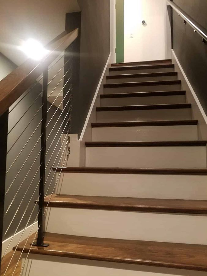 A staircase with wooden steps and a metal railing in a house.