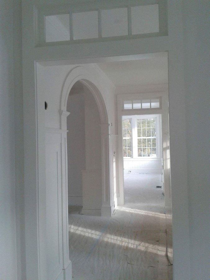 A hallway in a house with arched doors and windows.