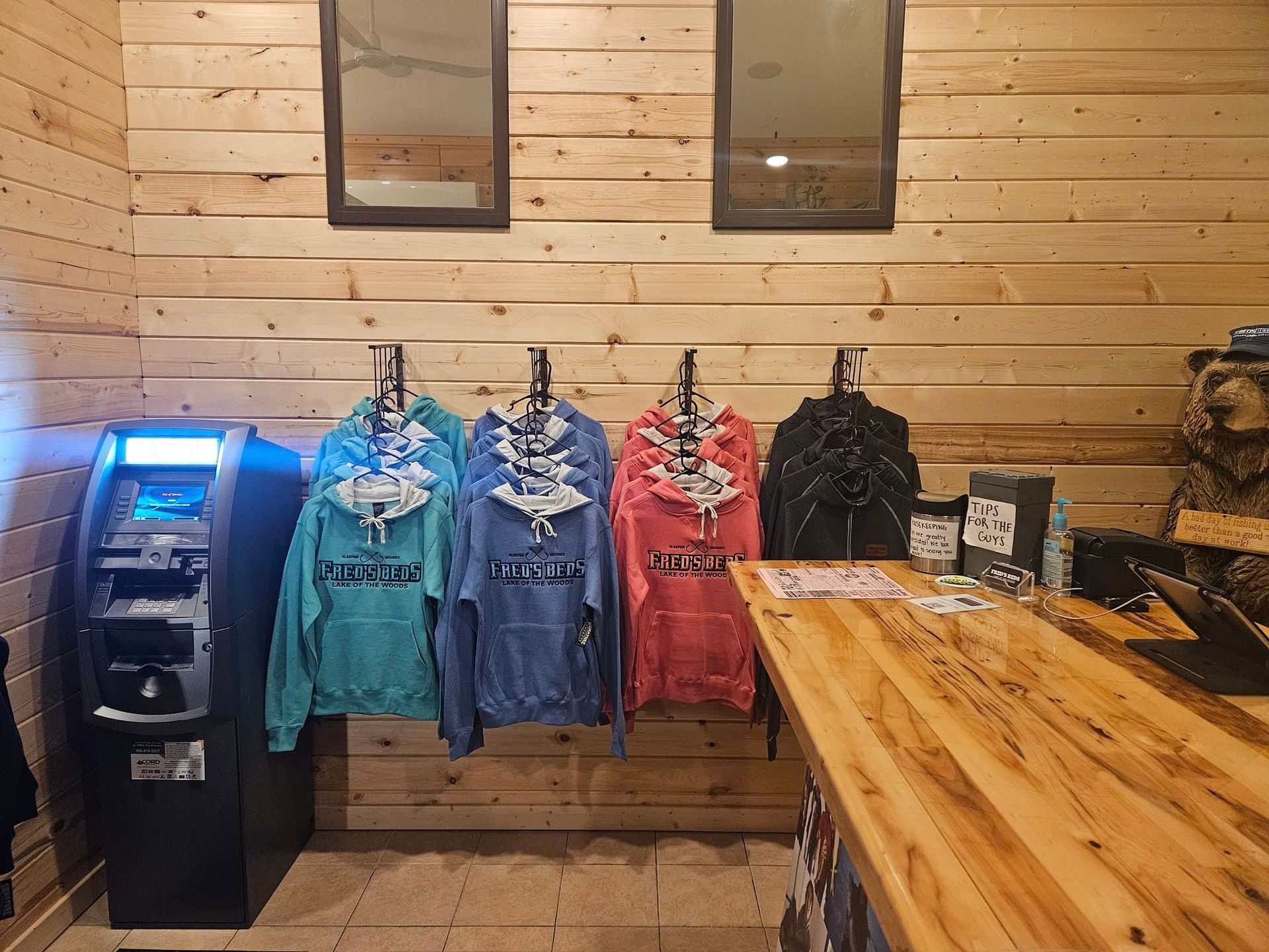 A row of hoodies are hanging on a wall in a store.
