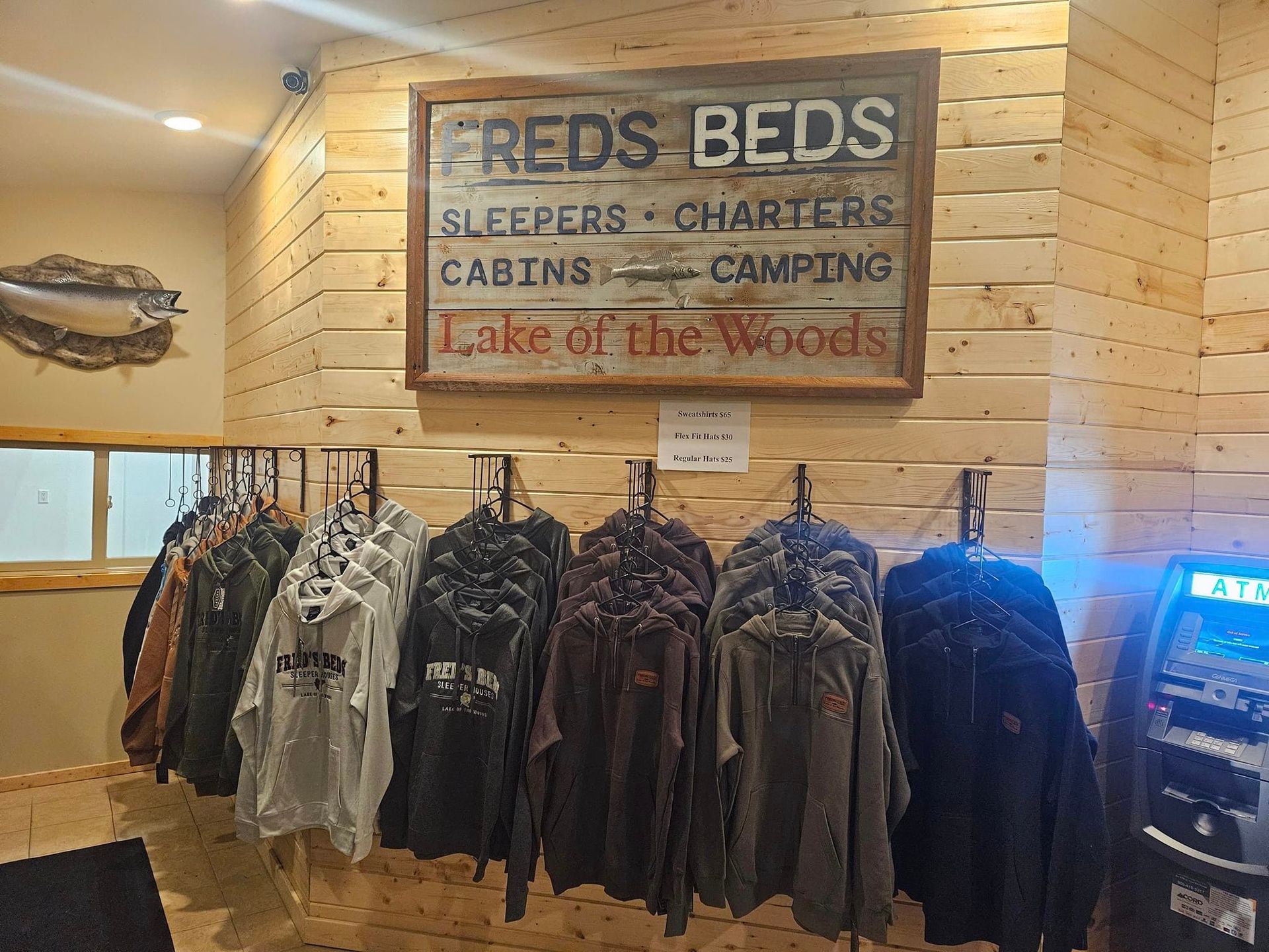 A row of jackets are hanging on a wall in front of a sign that says fred 's beds.