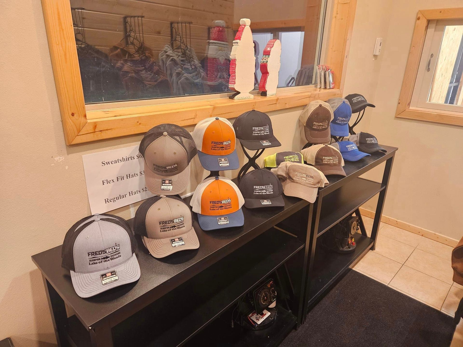 A bunch of hats are sitting on a table in front of a mirror.