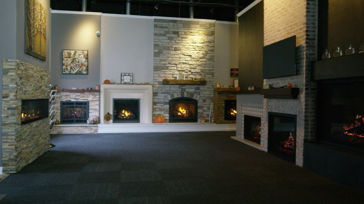 A living room with a fireplace and a flat screen tv on the wall.