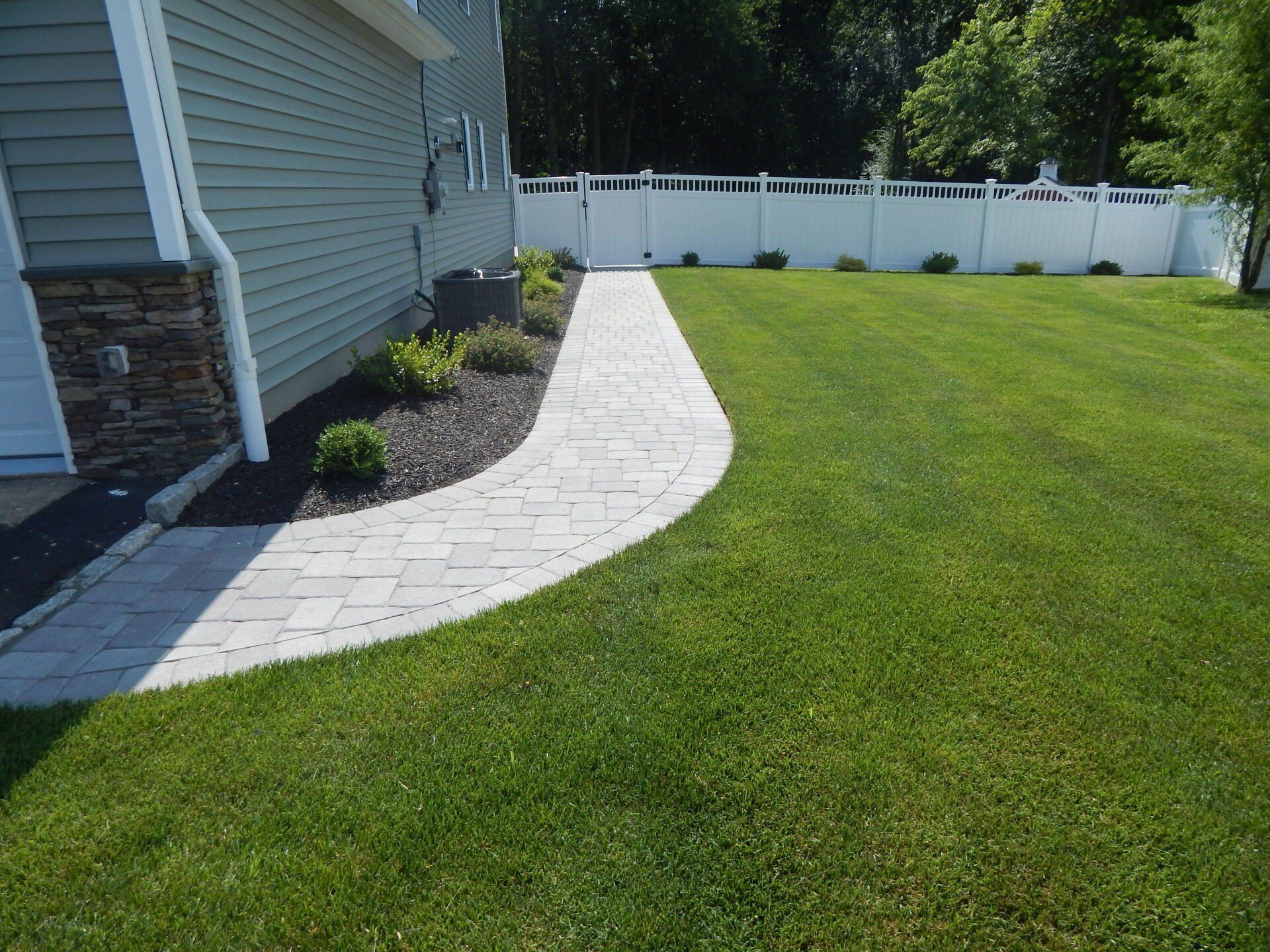 newly trimmed lawn garden with white fence