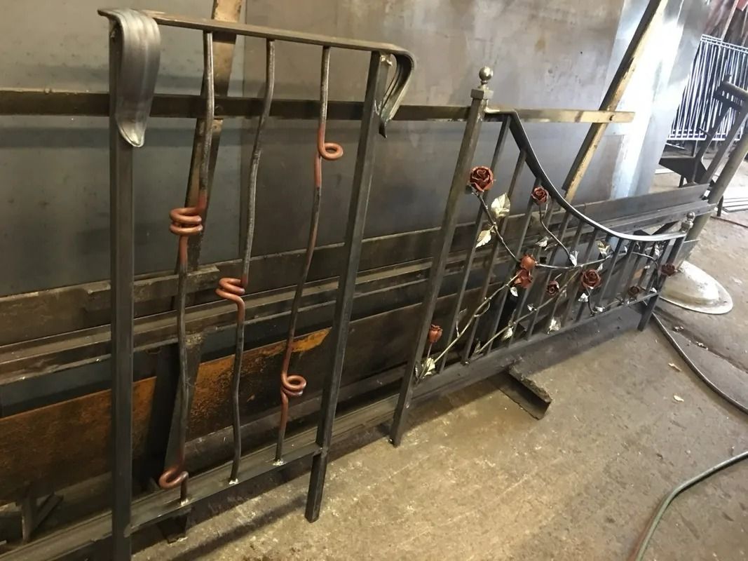 Metalwork: Two ornate wrought iron railing sections; one with curly designs, the other with decorative flowers.