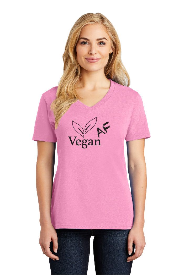 A woman is wearing a pink t-shirt that says vegan