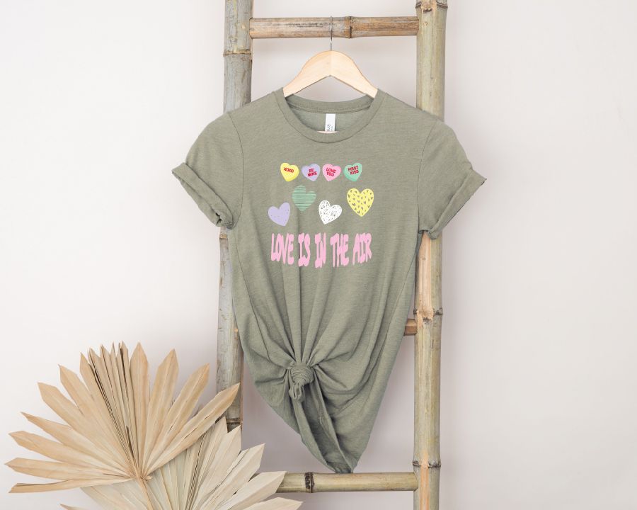 A t-shirt is hanging on a wooden ladder next to a palm tree.