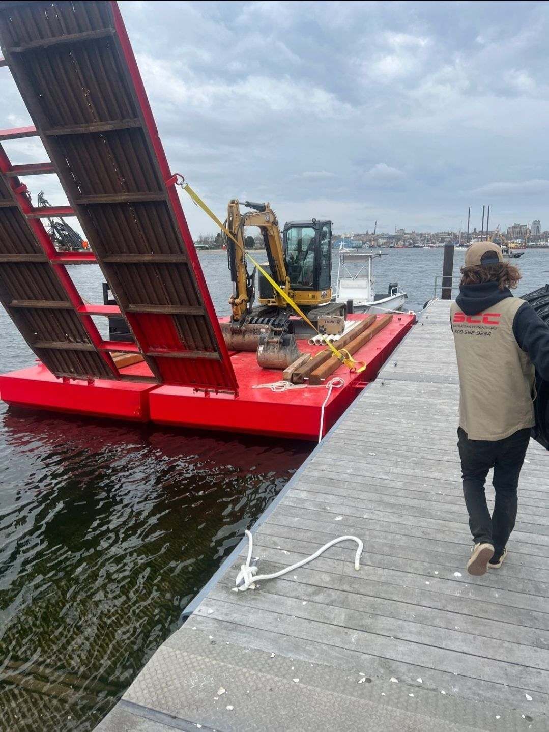 Red barge on water with excavator