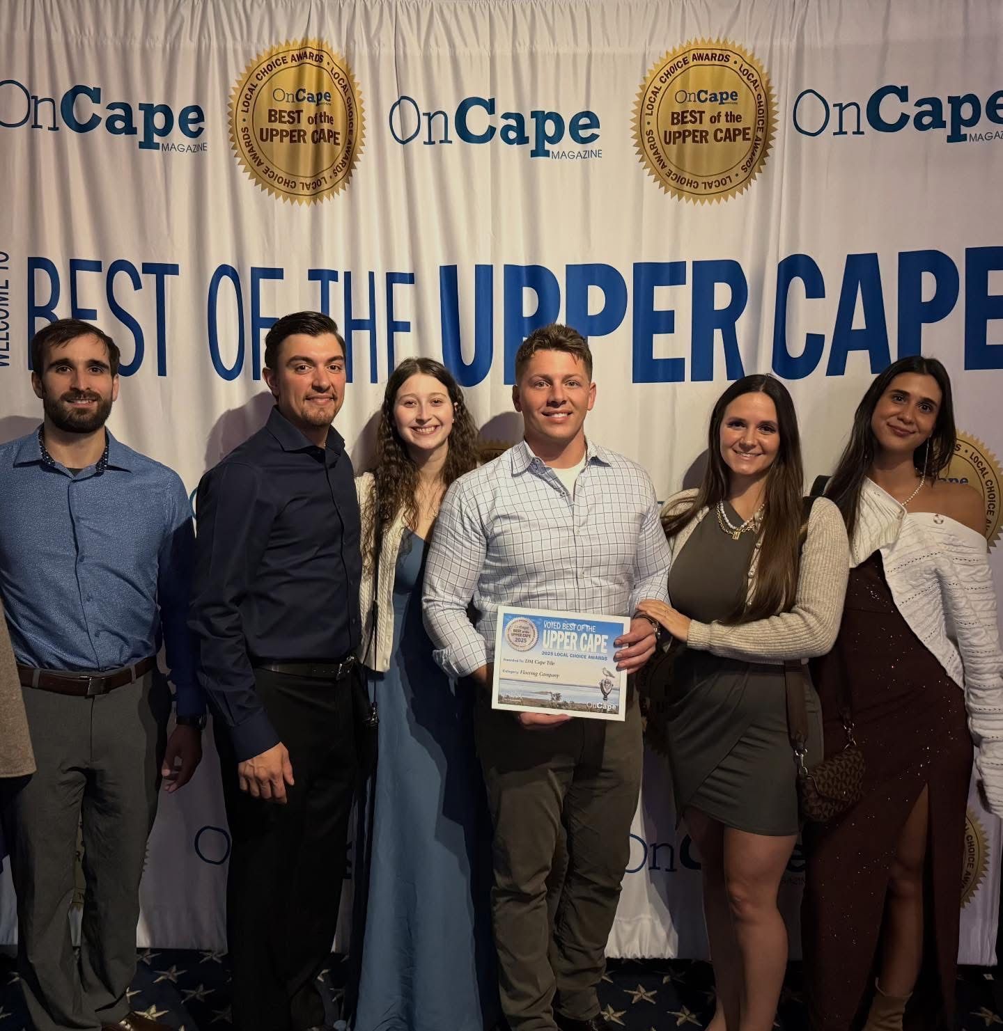 Group of people holding an award, standing in front of a