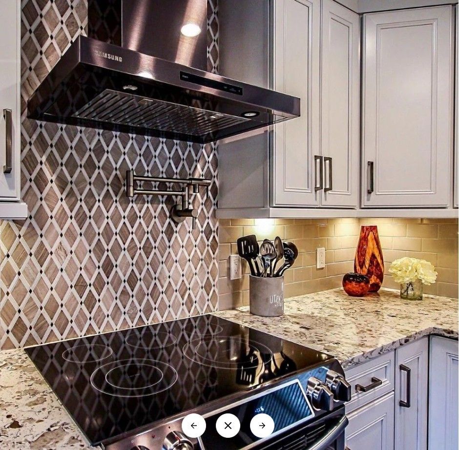 A kitchen with a stove top oven and a stainless steel hood