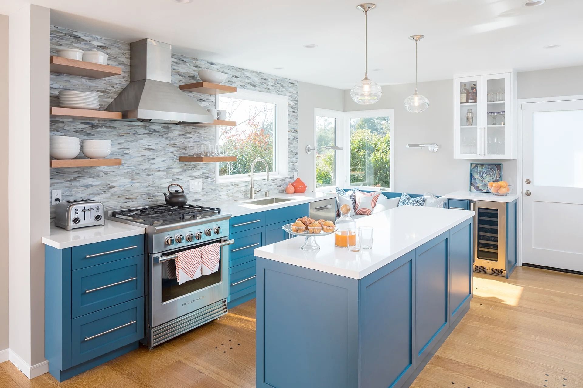 Modern kitchen with blue cabinets, white countertops, and a large island.
