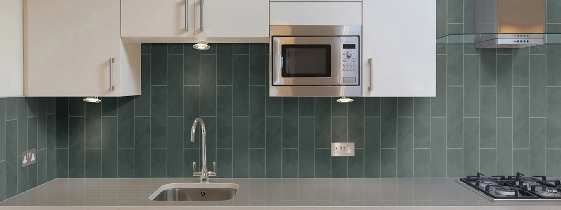 A kitchen with a sink , stove and microwave.