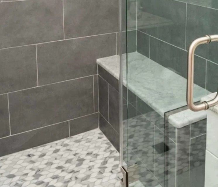 A bathroom with a walk in shower and a bench.