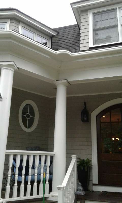 Beige and white house exterior with a porch, columns, and a front door.