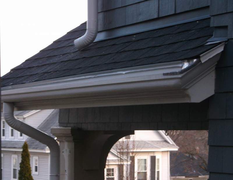 Gray roof with white gutters and downspout.