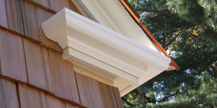 Wooden house exterior with white trim and cedar shingles.
