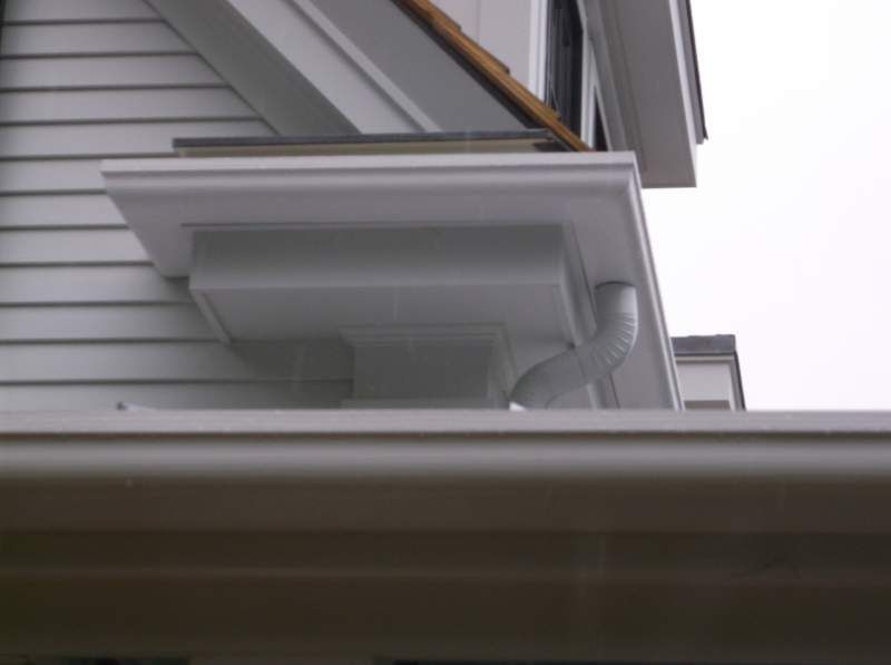 White house exterior with gutters and a square architectural detail.