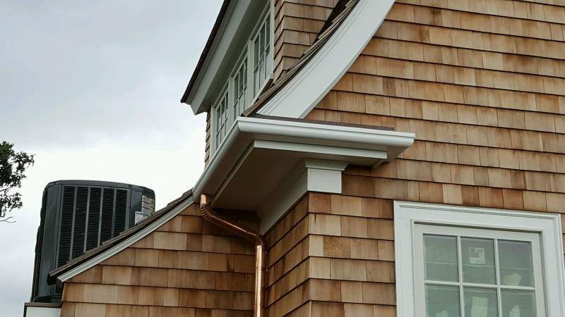 Exterior of a house with cedar shingles, white trim, and copper rain gutters.